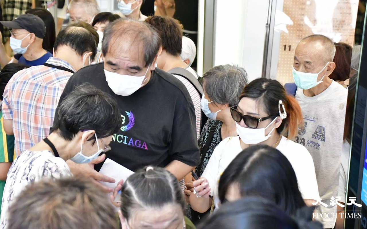 始創中心地下電梯大堂，下午仍不斷有市民排隊交表，記者發現大部分長者，皆對消費券申請表充滿疑問。（麥碧／大紀元）