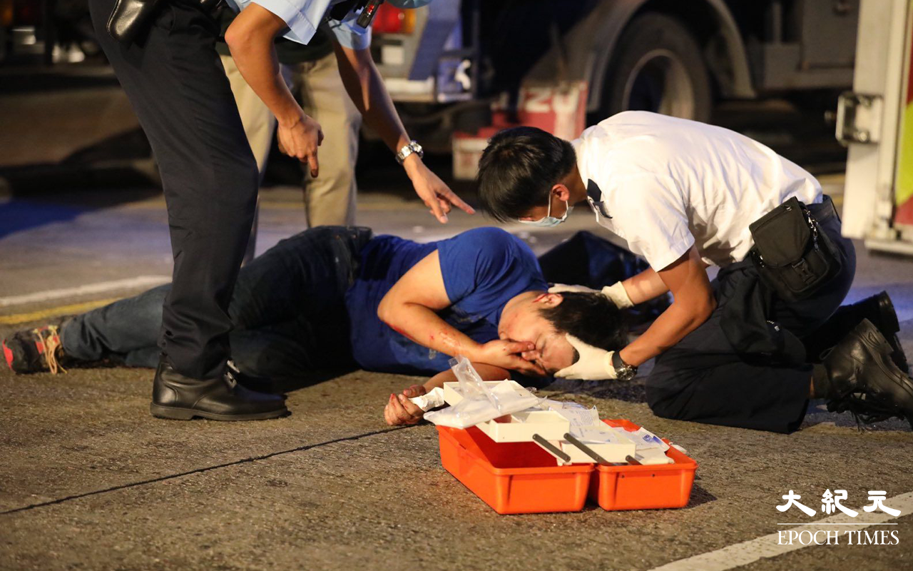 救護員為傷者稍作治理後，將傷者抬上擔架。（Yan／大紀元）