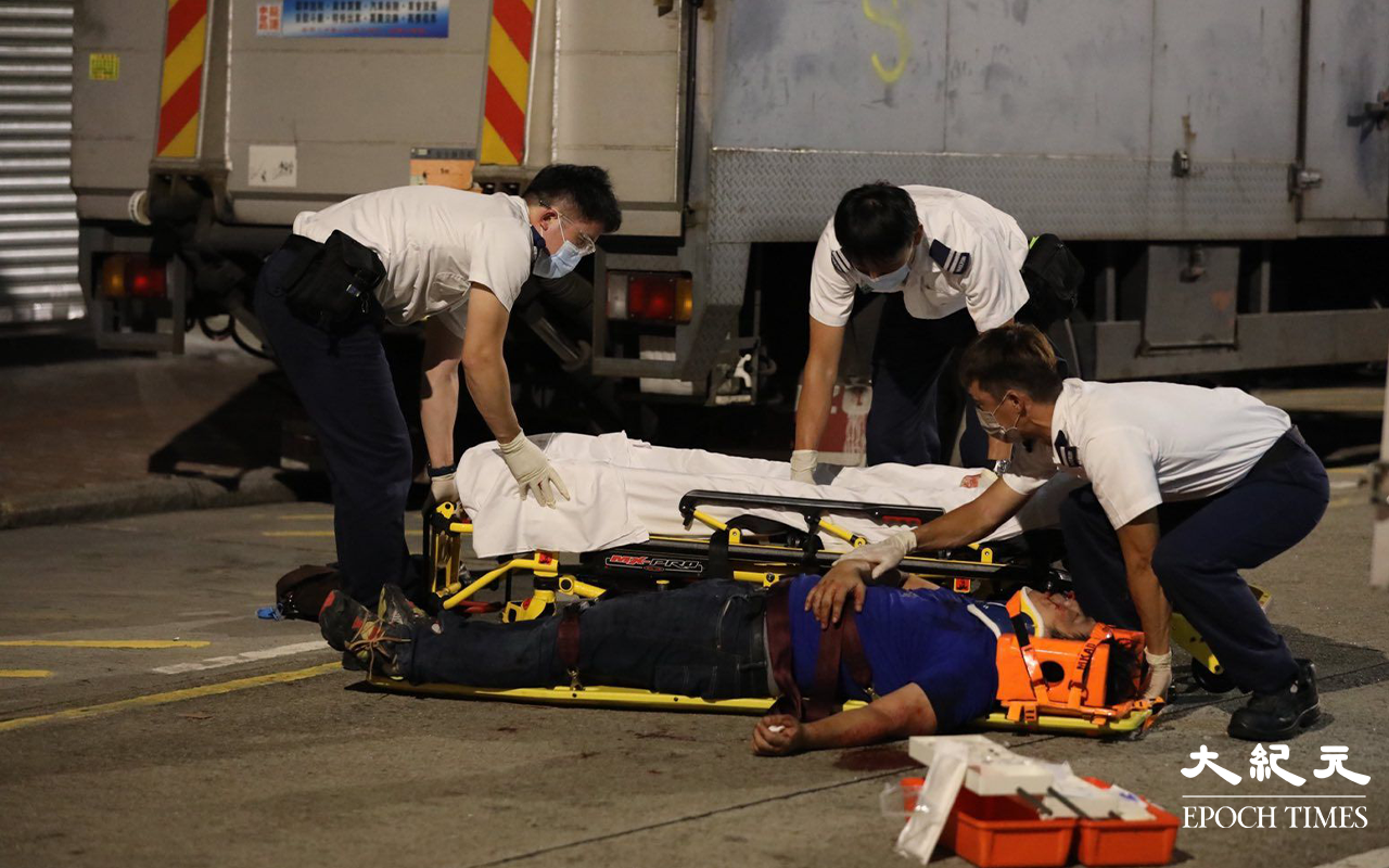 救護員將傷者抬上擔架，再由救護車送往廣華醫院治理。（Yan／大紀元）