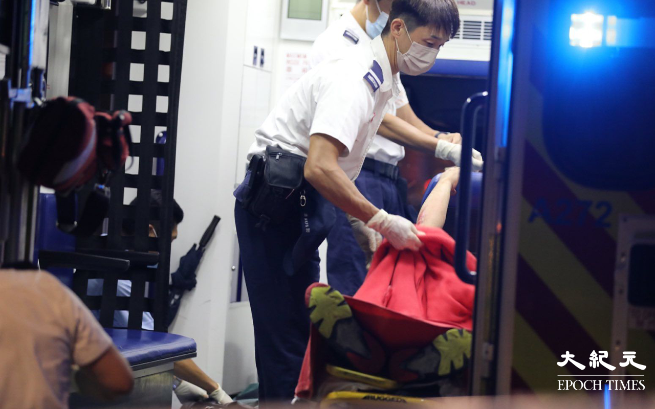 救護員將傷者抬上擔架，再由救護車送往廣華醫院治理。（Yan／大紀元）