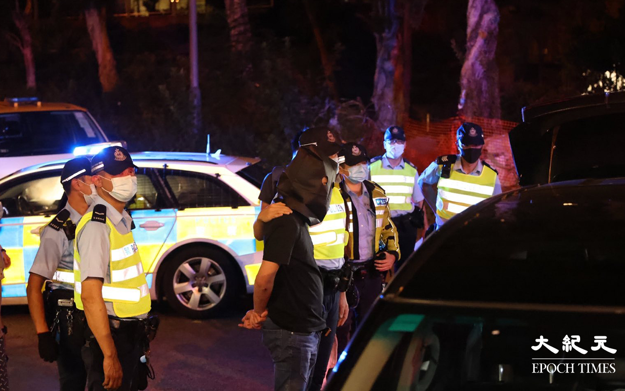 七人車內一對男女被拘捕後，警方將二人押返現場，看掃毒組探員在七人車內搜證。（李辰／大紀元）