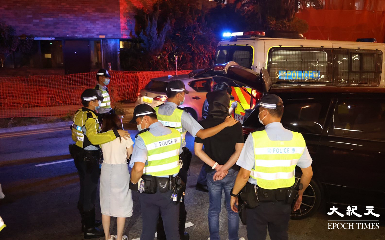 七人車內一對男女被拘捕後，警方將二人押返現場，看掃毒組探員在七人車內搜證。（李辰／大紀元）