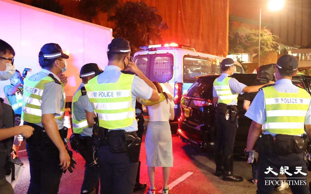 七人車內一對男女被拘捕後，警方將二人押返現場，看掃毒組探員在七人車內搜證。（李辰／大紀元）