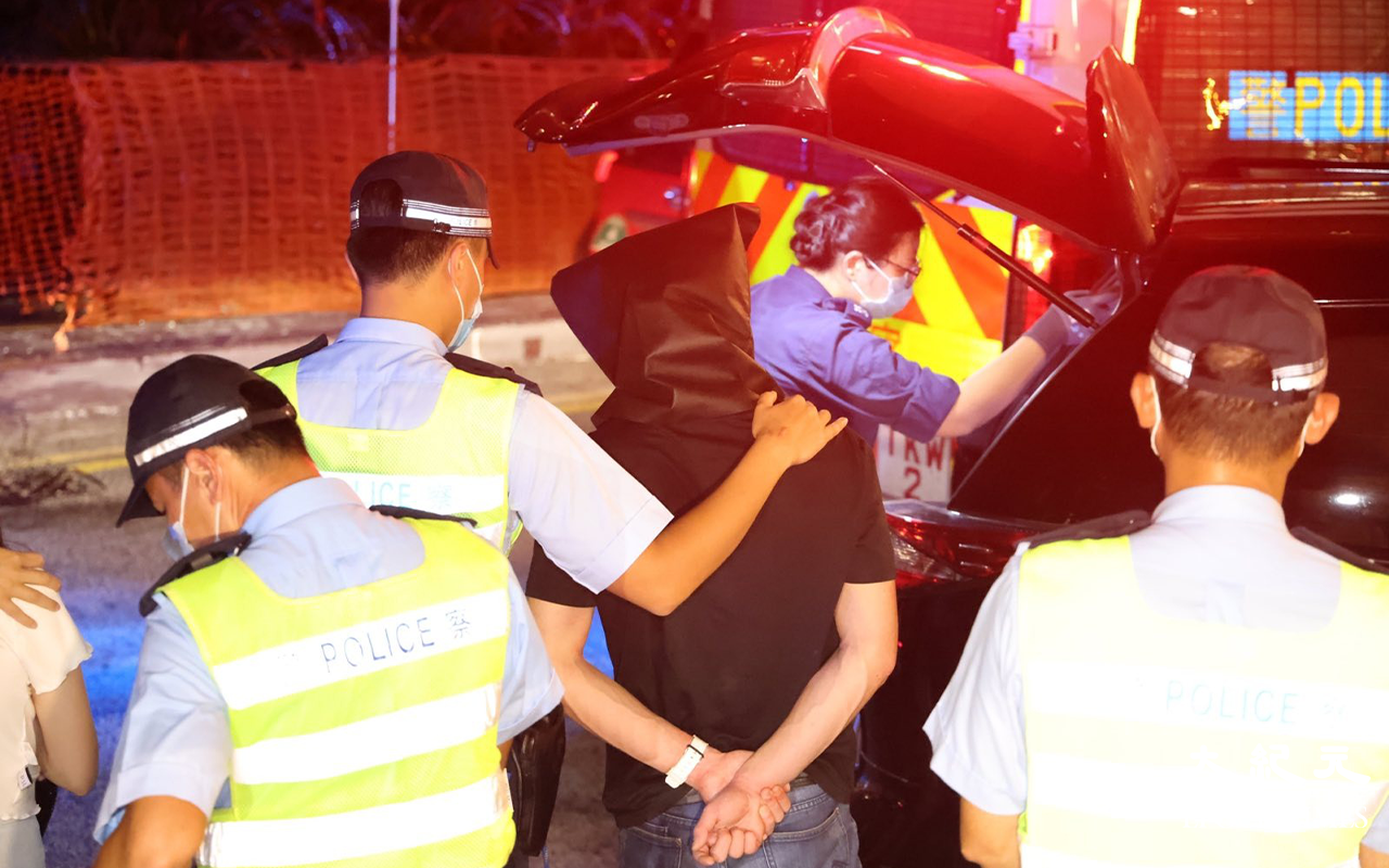 七人車內一對男女被拘捕後，警方將二人押返現場，看掃毒組探員在七人車內搜證。（李辰／大紀元）