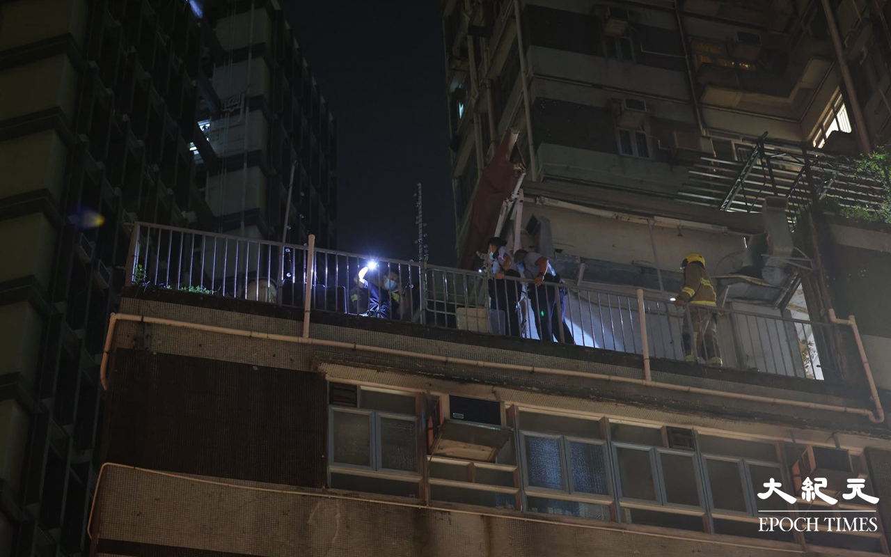 加連威老道威華大廈平台火警被救熄後，消防員及警方在火警位置調查起火原因。（李辰／大紀元）