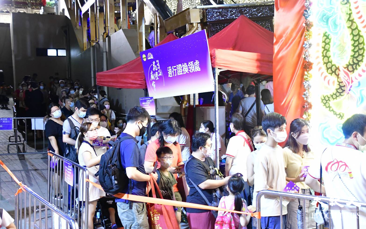 市民一家大小在排隊，換領通行證進入攤位區。（麥碧／大紀元）