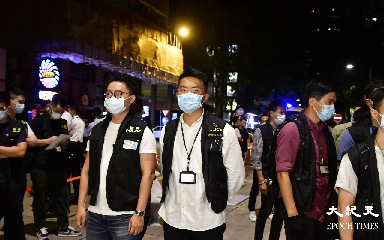 負責指揮這次拘捕行動的探員 : (左白衣)灣仔警區情報組主管陳敬樂督察、(右白衣)灣仔反三合會主管吳以諾督察。（麥碧／大紀元）