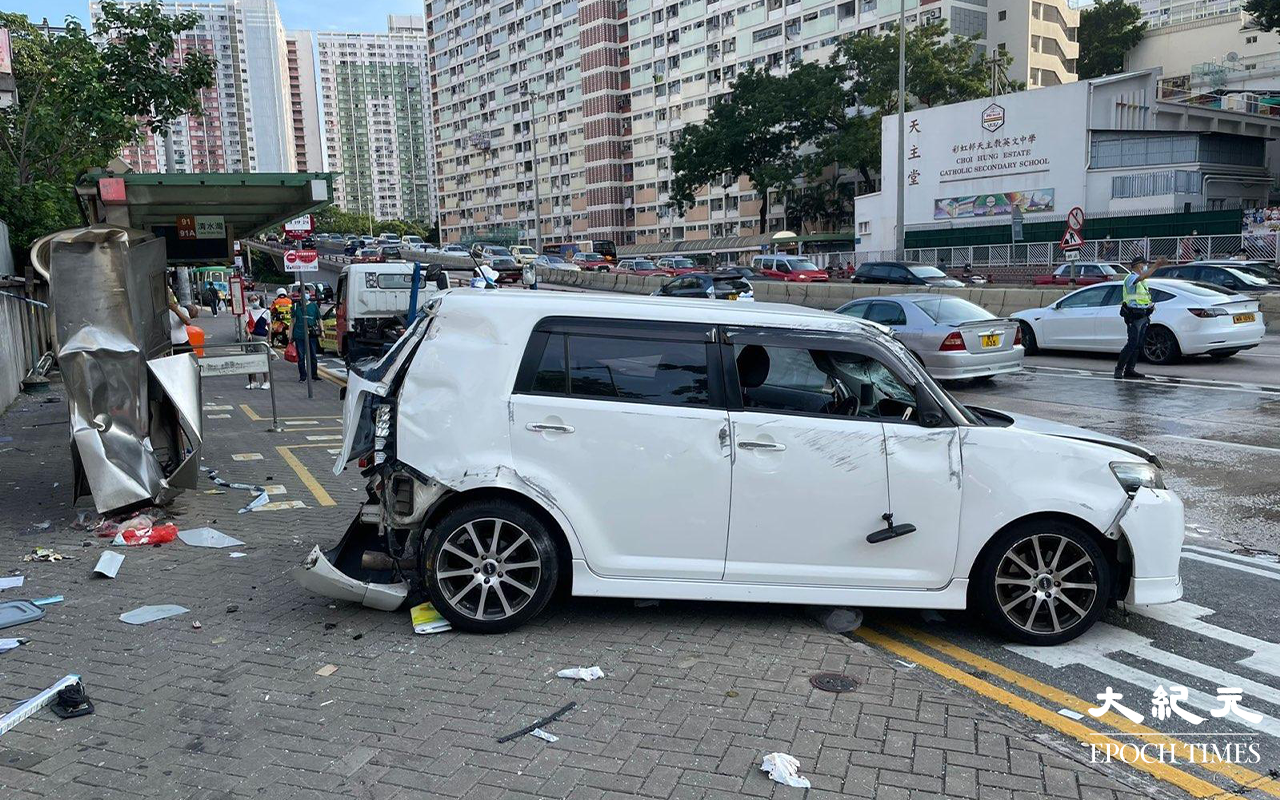 涉事的白色私家車，左邊車頭損毀、擋風玻璃碎裂、車尾泵把被撞至飛脫，私家車調頭停在龍翔道上，男司機和女乘客，分別送往聯合醫院及伊利沙伯醫院治理。（卓相如／大紀元）