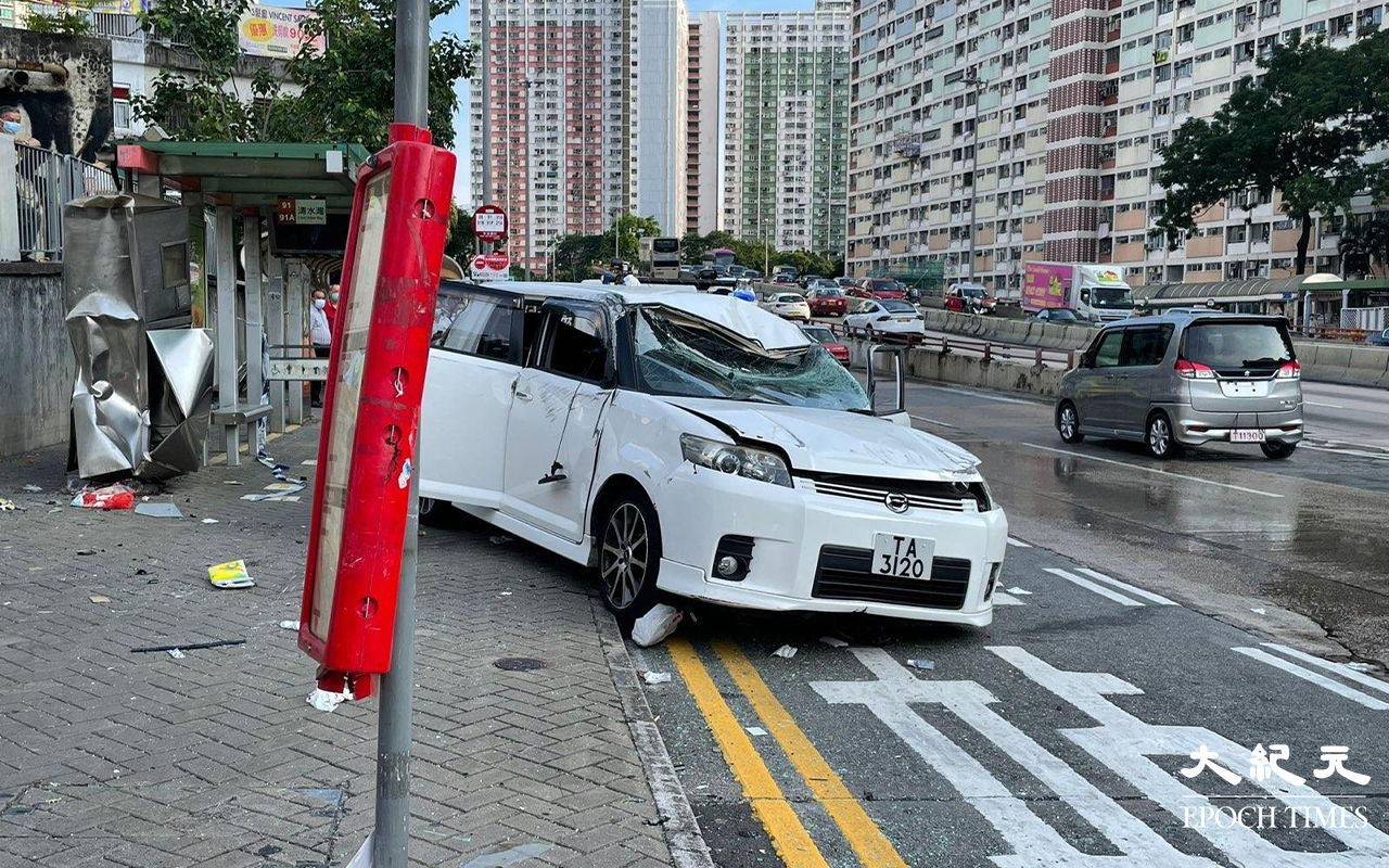 涉事的白色私家車，左邊車頭損毀、擋風玻璃碎裂、車尾泵把被撞至飛脫，私家車調頭停在龍翔道上，男司機和女乘客，分別送往聯合醫院及伊利沙伯醫院治理。（卓相如／大紀元）
