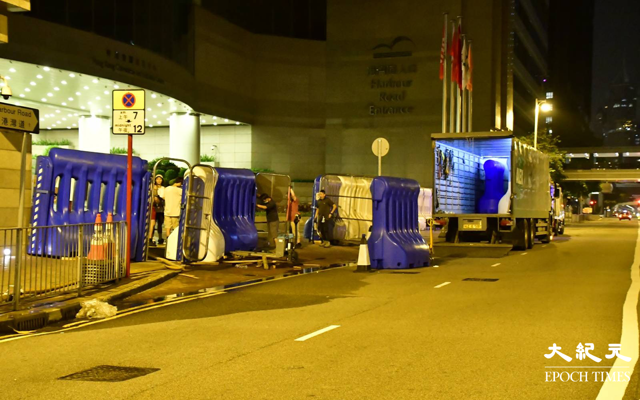 今日 (30日) 凌晨一時許，陸續有貨車將水馬運抵港灣道會展舊翼出入口，工人在架設水馬。（麥碧／大紀元）