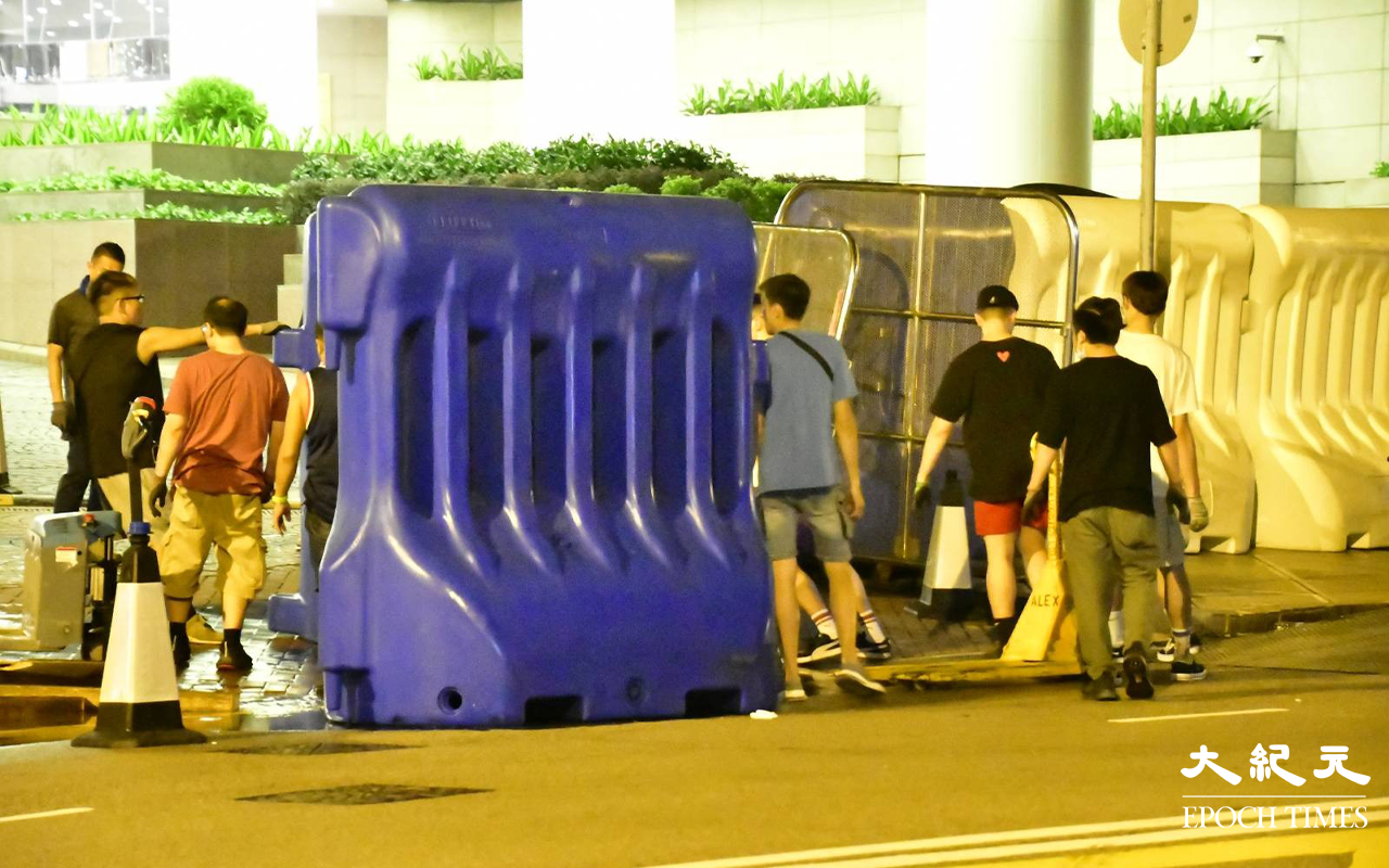 今日 (30日) 凌晨一時許，陸續有貨車將水馬運抵港灣道會展舊翼出入口，工人在架設水馬。（麥碧／大紀元）