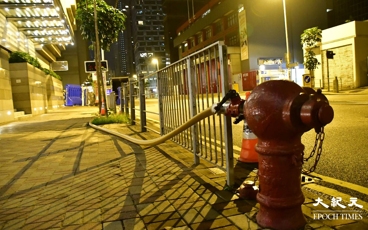 工人開動港灣道一條消防喉，為水馬注水。（麥碧／大紀元）