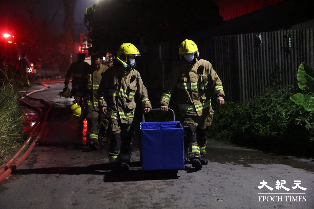 消防於晚上10時30分將鐵皮屋火警救熄後，大批消防員仍然在場戒備，以及不時向起火鐵皮屋射水降溫，以防死灰復燃。（李辰／大紀元）