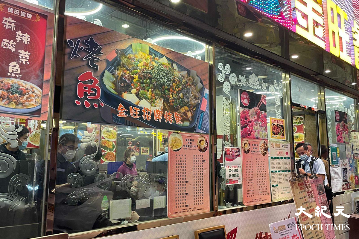 大批警員接報後，趕抵位於砵蘭街的金旺餐廳，拘捕懷疑藏有違禁品的男子後，並向餐廳內多名人士錄取口供。（卓相如／大紀元）