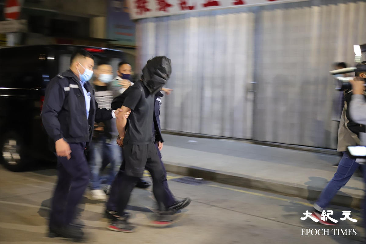 被警方以販毒罪名拘捕的24歲男子，被押到涉案私家車旁，協助緝毒組探員在涉案私家車搜證。（譚嘉嘉／大紀元）