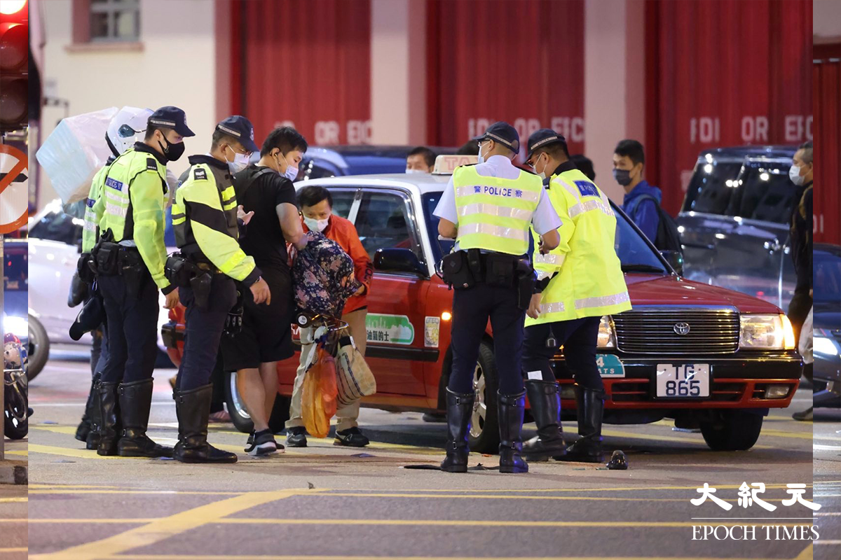 警方接報後趕抵現場，接手調查交通意外，橙衣者為的士司機。（李辰／大紀元）