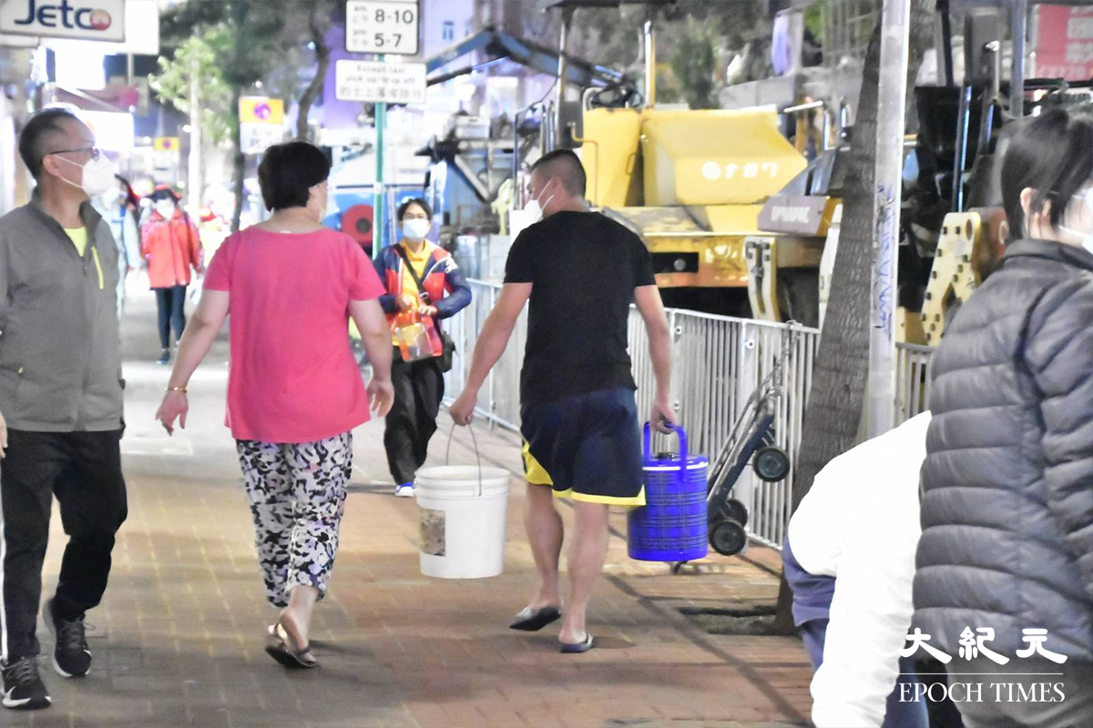 水務署安排水車及開放街喉，為受地底食水管爆裂影響的居民，提供臨時食水，有不少居民自行準備水桶盛載食水回家使用。（麥碧／大紀元）