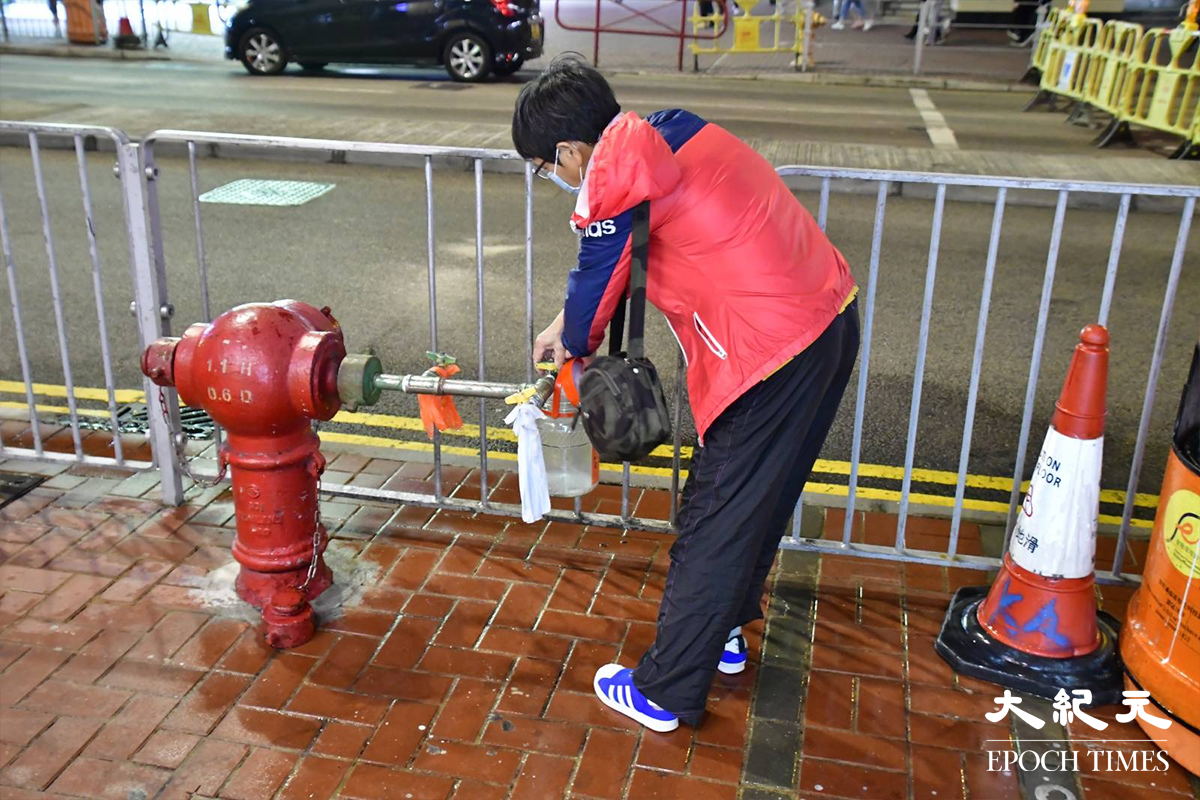 水務署安排水車及開放街喉，為受地底食水管爆裂影響的居民，提供臨時食水，有不少居民自行準備水桶盛載食水回家使用。（麥碧／大紀元）