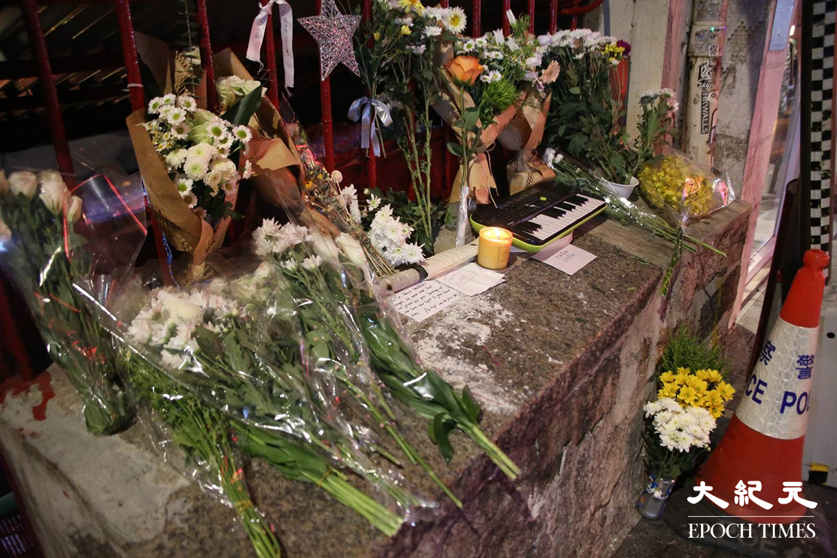 發生奪命交通意外的士丹頓街石壆上，市民放滿了鮮花，蠟燭，電子琴及心意卡等，以悼念因事故延至11日離世的27歲法籍女士。（金國米／大紀元）
