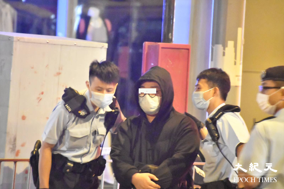 被警方在身上搜出，少量懷疑可卡因的36歲的士司機，於緝毒組探員到場後，被警方押至涉案的士旁協助調查。（麥碧／大紀元）