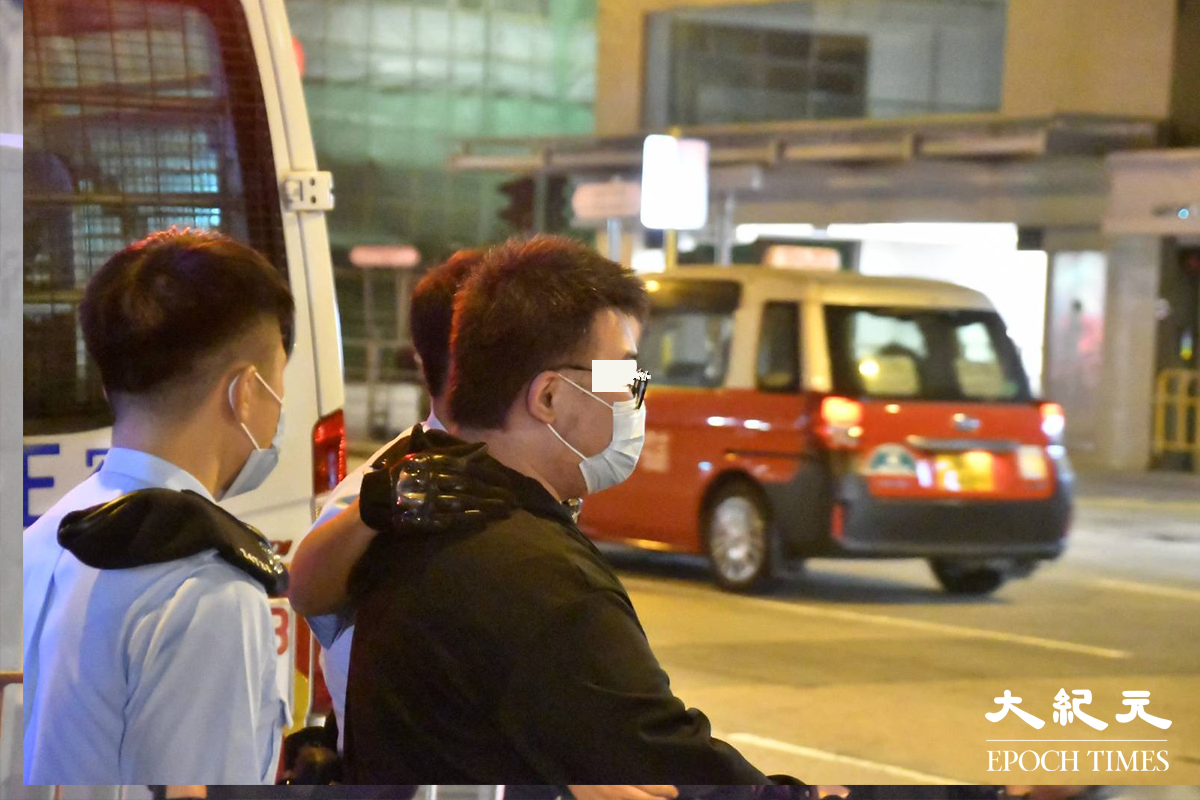 被警方在身上搜出，少量懷疑可卡因的36歲的士司機，於緝毒組探員到場後，被警方押至涉案的士旁協助調查。（麥碧／大紀元）