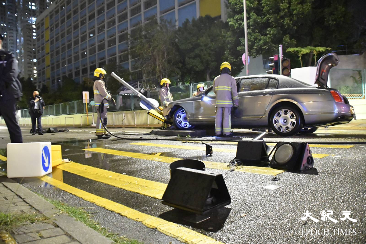 掛有中港牌的名貴私家車，高速撞毀恆富街一個安全島後，安全島的燈箱及交通燈膠等物件散落一地。（麥碧／大紀元）
