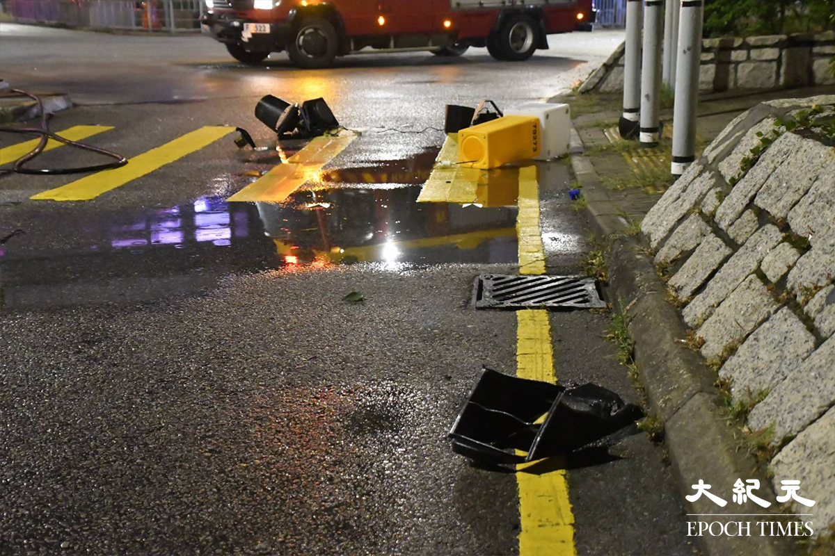 掛有中港牌的名貴私家車，高速撞毀恆富街一個安全島後，安全島的燈箱及交通燈膠等物件散落一地。（麥碧／大紀元）