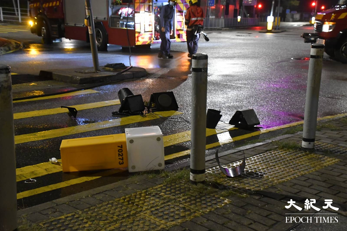 掛有中港牌的名貴私家車，高速撞毀恆富街一個安全島後，安全島的燈箱及交通燈膠等物件散落一地。（麥碧／大紀元）