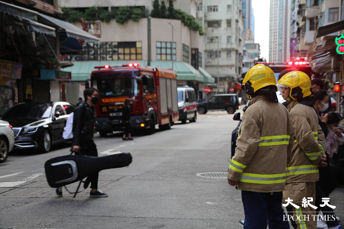 消防接報後隨即派出5輛消防車及1輛救護車趕抵現場，有消防員攜帶手提滅火裝備，進入大廈後樓梯電錶房位置。（金國米／大紀元）