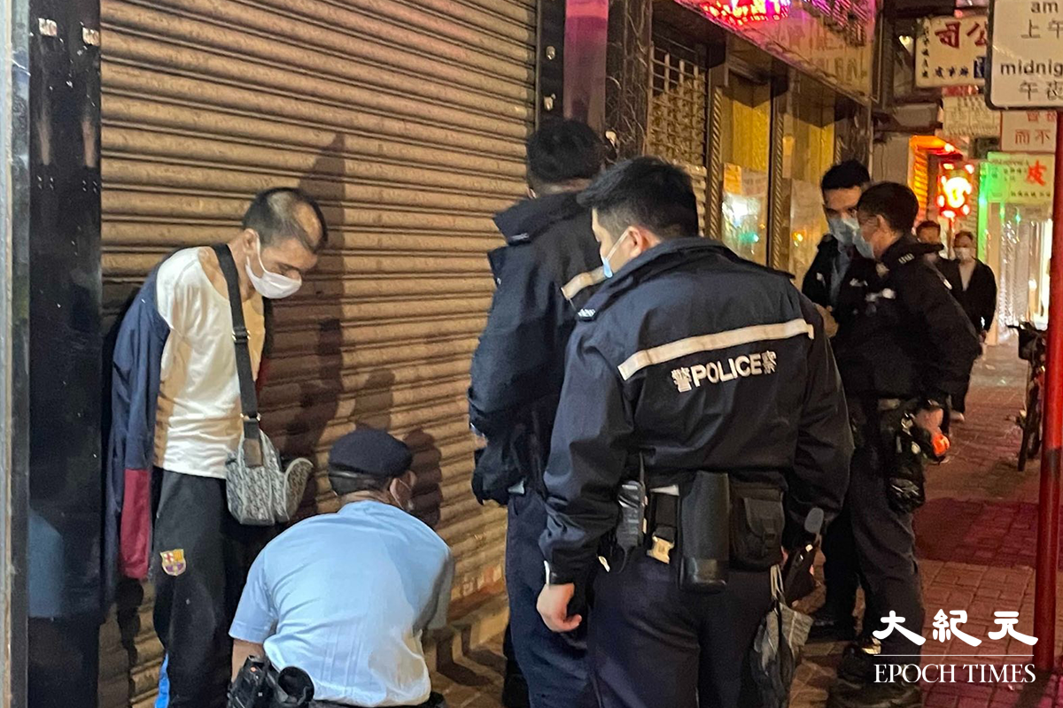 一名年約40歲的男子，被警方在其身上搜出少量懷疑海洛英，在場警員隨即將其鎖上手銬，並帶返旺角警署通宵扣查。（卓相如／大紀元）