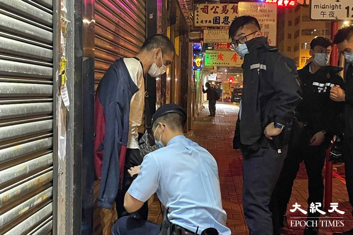 一名年約40歲的男子，被警方在其身上搜出少量懷疑海洛英，在場警員隨即將其鎖上手銬，並帶返旺角警署通宵扣查。（卓相如／大紀元）