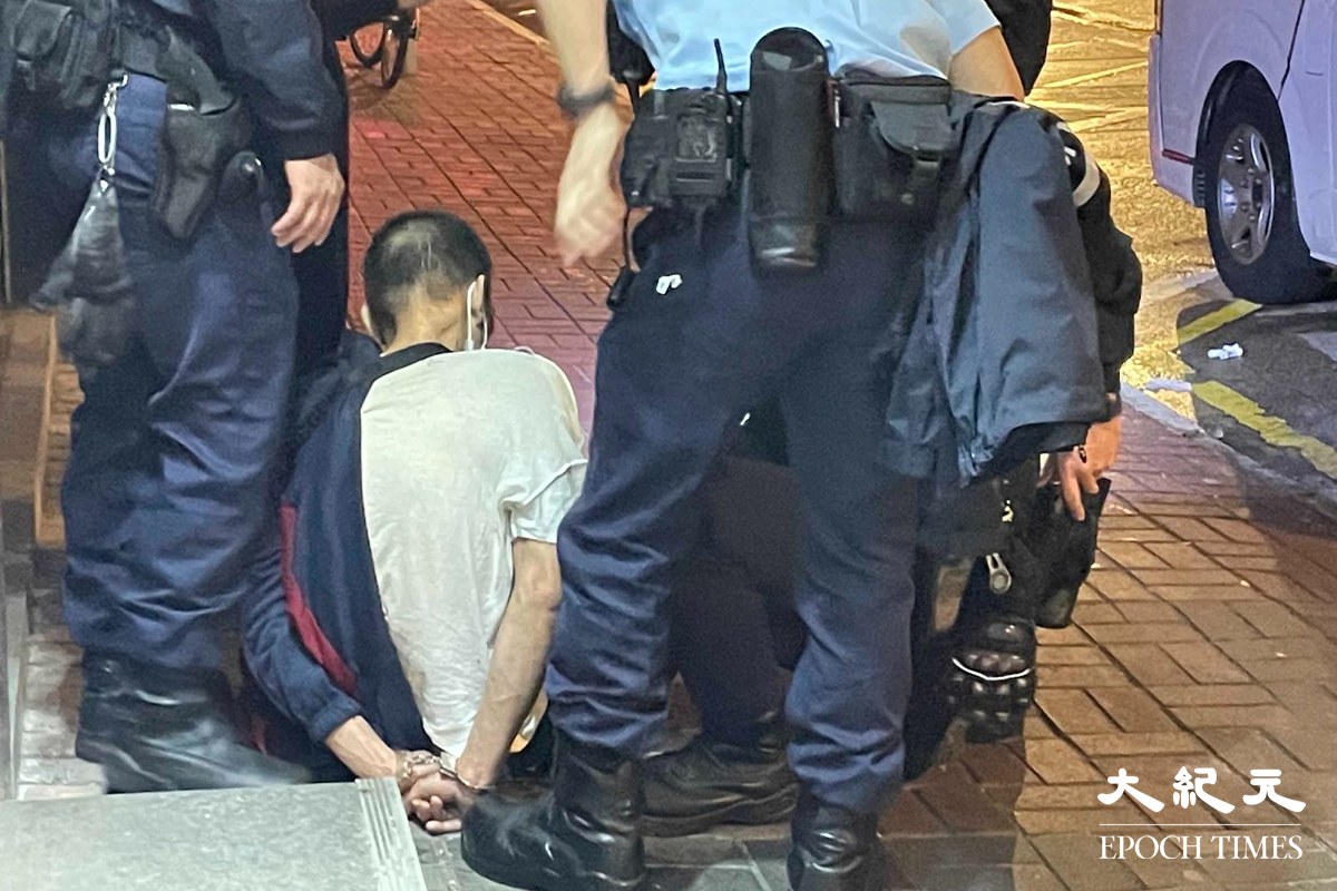 一名年約40歲的男子，被警方在其身上搜出少量懷疑海洛英，在場警員隨即將其鎖上手銬，並帶返旺角警署通宵扣查。（卓相如／大紀元）