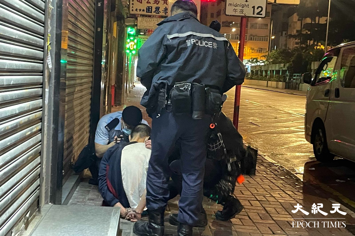 一名年約40歲的男子，被警方在其身上搜出少量懷疑海洛英，在場警員隨即將其鎖上手銬，並帶返旺角警署通宵扣查。（卓相如／大紀元）