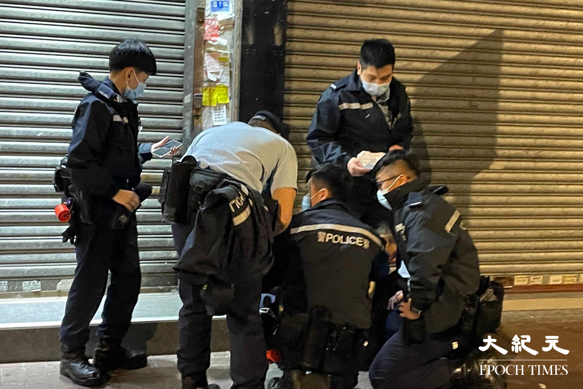 一名年約40歲的男子，被警方在其身上搜出少量懷疑海洛英，在場警員隨即將其鎖上手銬，並帶返旺角警署通宵扣查。（卓相如／大紀元）