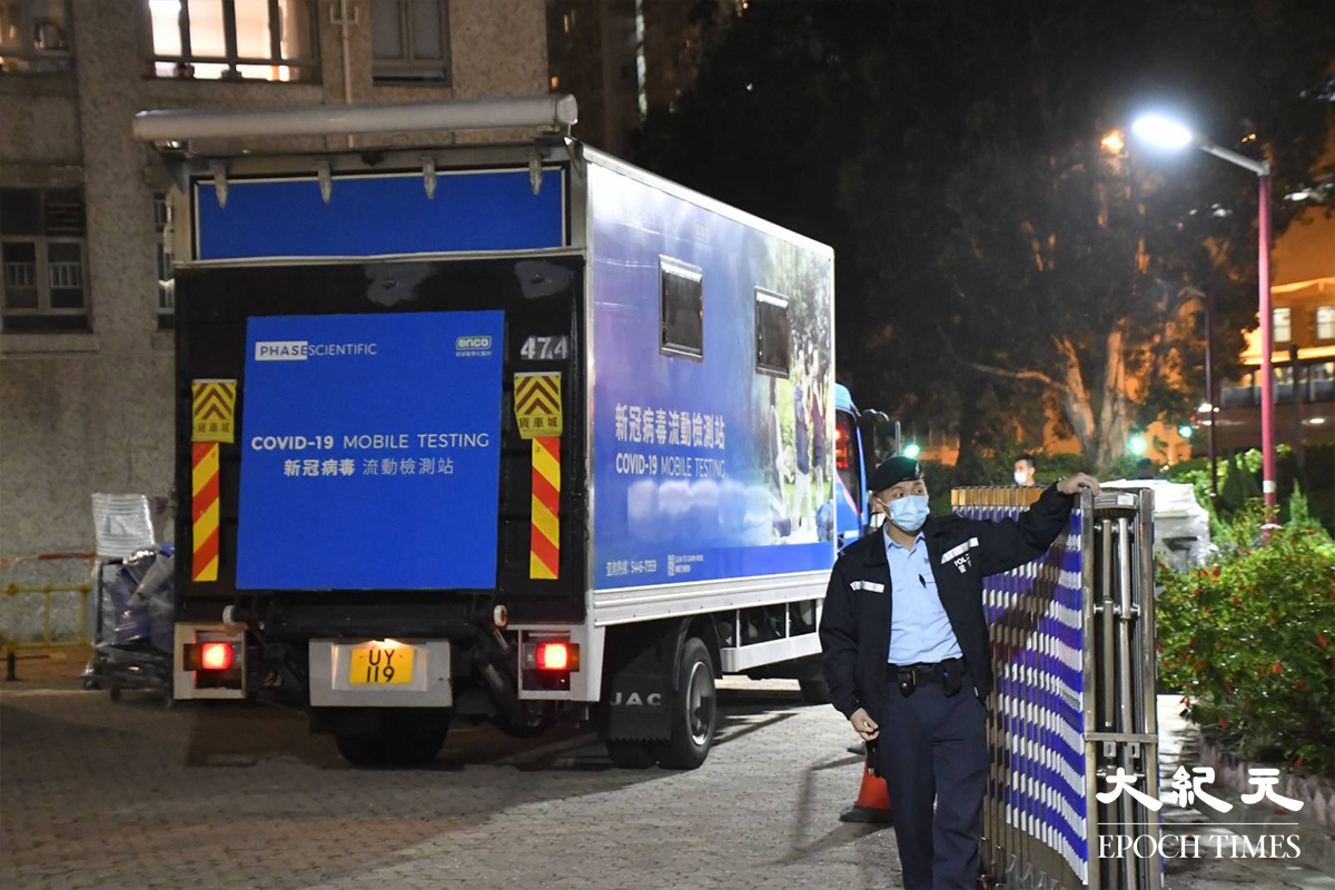 政府於晚上7時30分刊憲圍封強檢安禧閣後，陸續有流動檢測車及物資貨車進入圍封範圍。鋼閘內就是，今晚被圍封強檢的屯門兆禧苑安禧閣。（麥碧／大紀元）