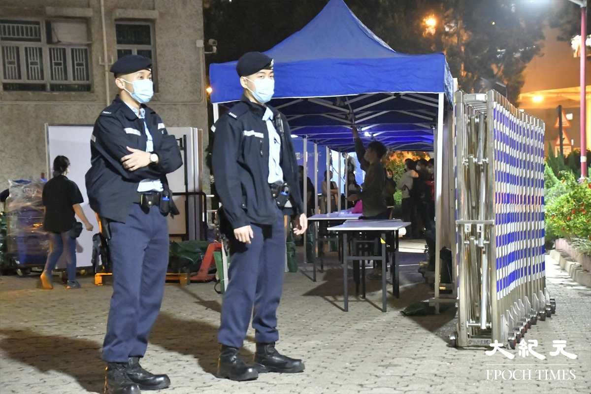 晚上7時30分開始，警方身後的安禧閣，正式被圍封為受限區域。（麥碧／大紀元）