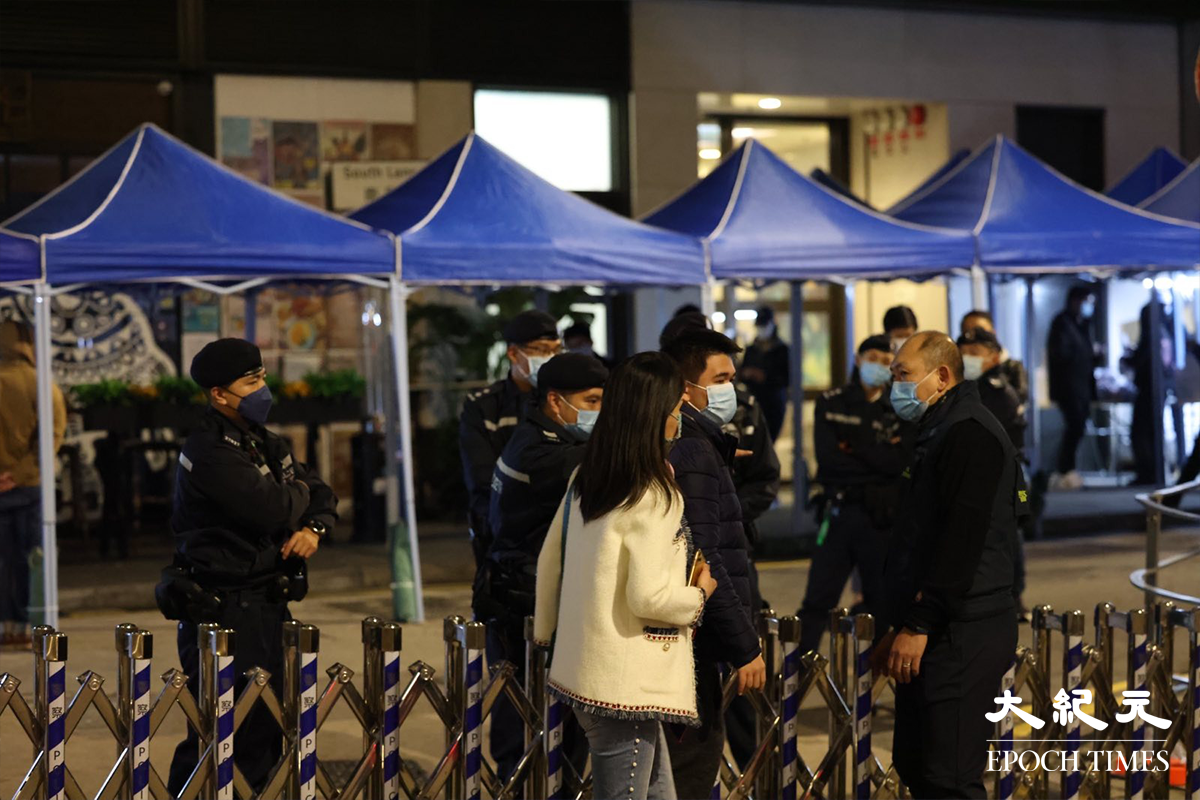 剛返回「南里1號」的女子，向在場警員諮詢有關封區強檢情況。（李辰／大紀元）