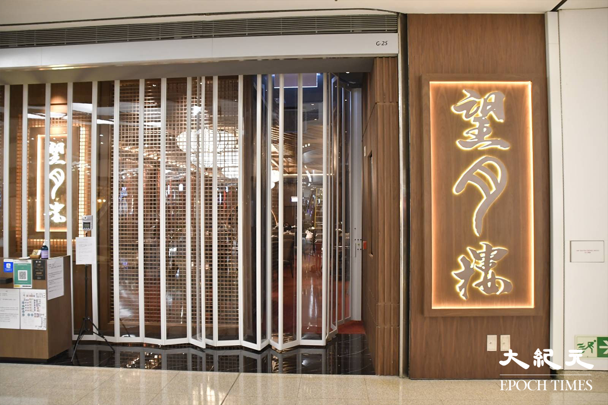 一直逗留在望月樓內的員工拒絕回答記者問題後，有一名男子將望月樓門口的趟閘關上。（麥碧／大紀元）