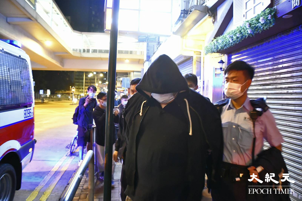 凌晨2時47分，警方將一名涉嫌「販毒」的男子，以及在房間內搜出約20克懷疑可卡因毒品，押上警車，帶返旺角警署通宵扣查。（麥碧／大紀元）