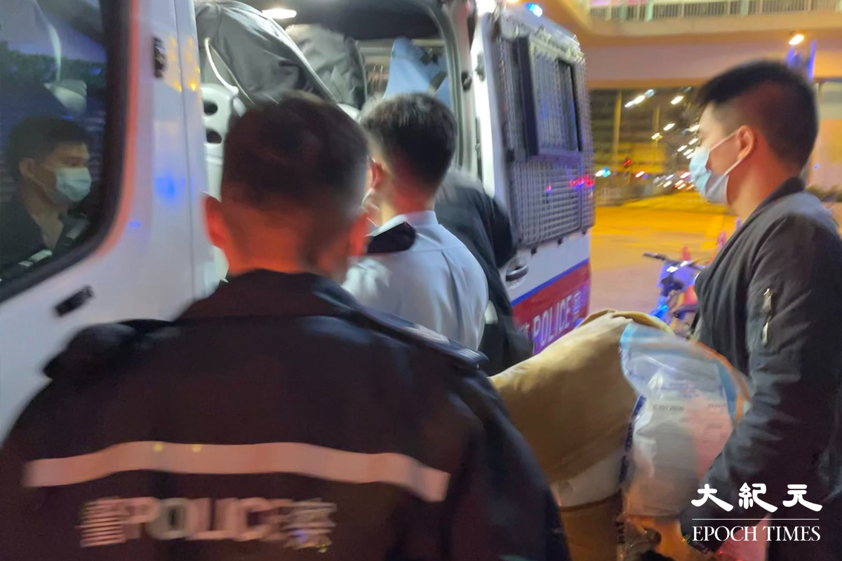 凌晨2時47分，警方將一名涉嫌「販毒」的男子，以及在房間內搜出約20克懷疑可卡因毒品，押上警車，帶返旺角警署通宵扣查。（麥碧／大紀元）