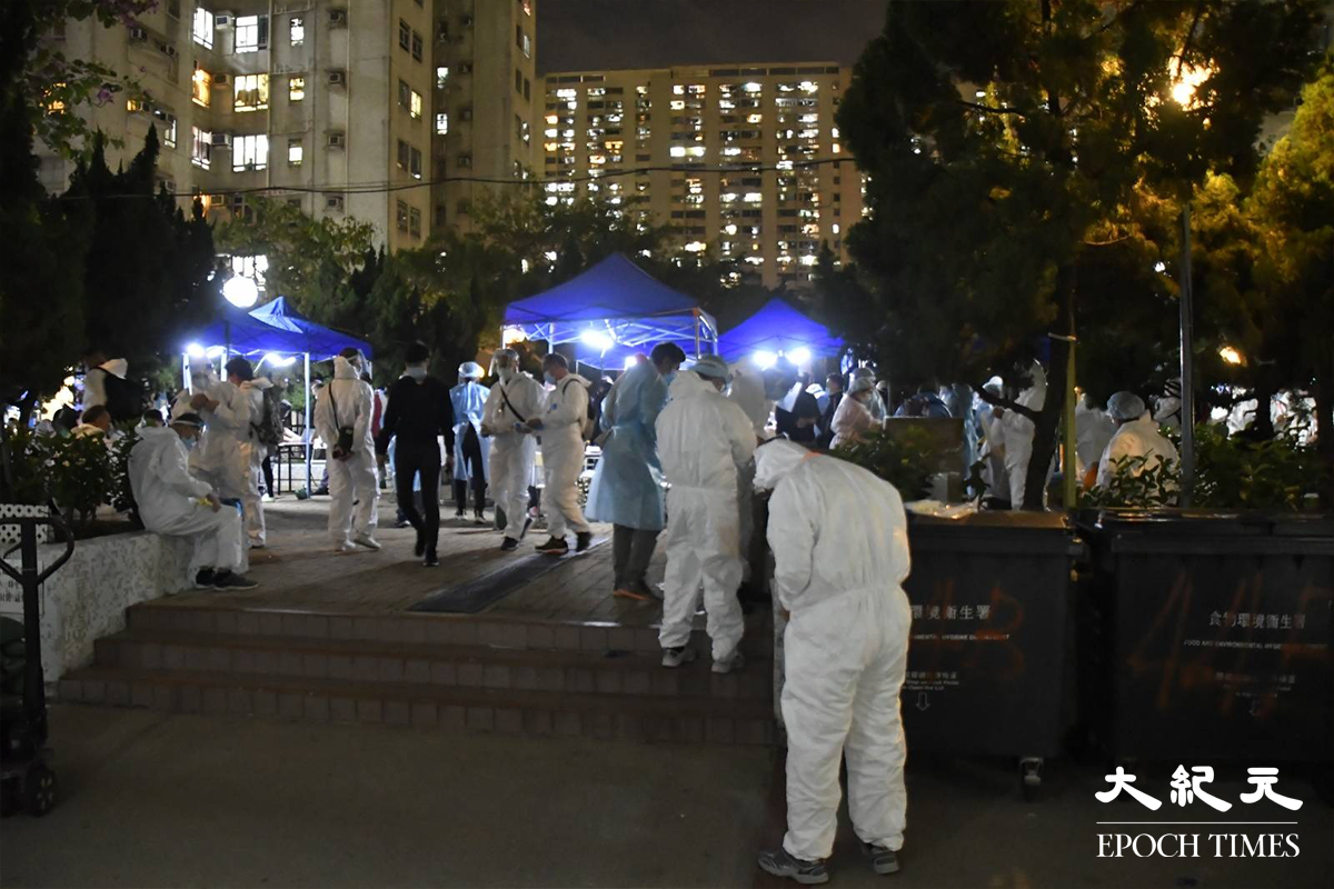 大批工作人員於翠寧花園第2座對開一個公園內，更換上全套保護衣。（麥碧／大紀元）