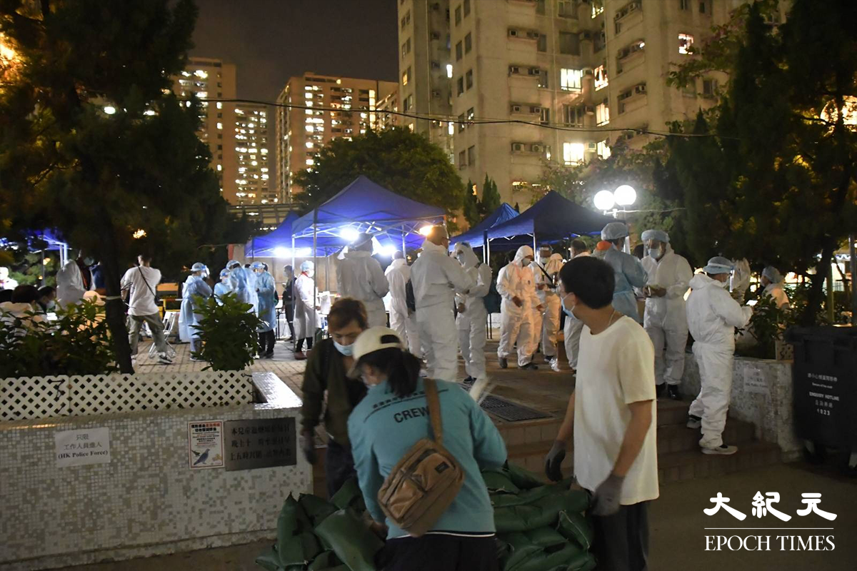 大批工作人員於翠寧花園第2座對開一個公園內，更換上全套保護衣。（麥碧／大紀元）