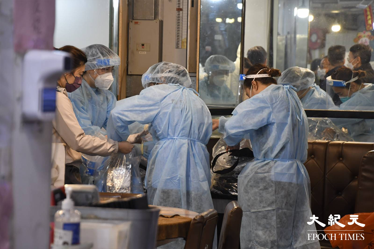 穿著全套保護裝備的工作人員，於陸田園餐廳內收拾蒐集到的環境樣本後離開。（麥碧／大紀元）