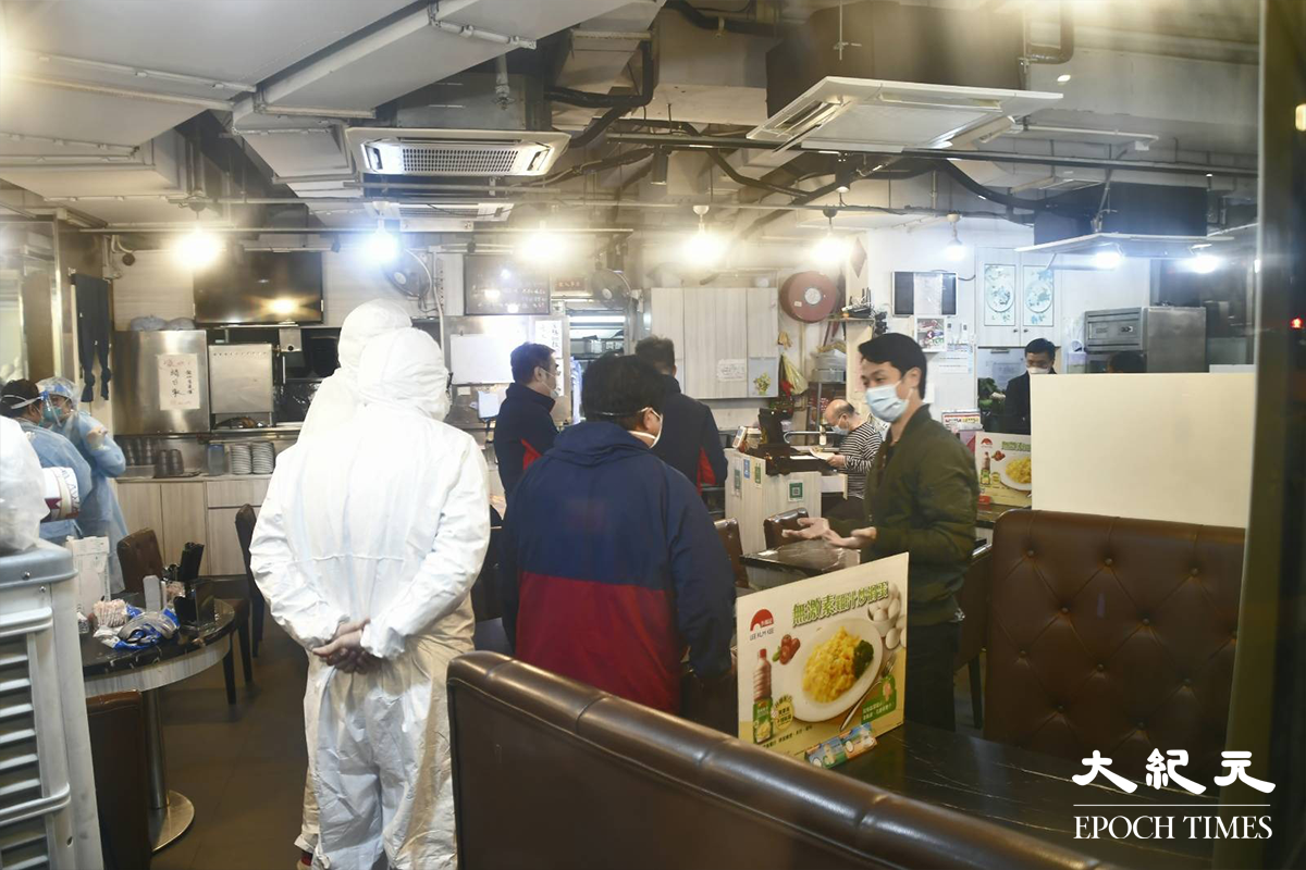 穿著全套保護裝備的工作人員，於陸田園餐廳內收拾蒐集到的環境樣本後離開。（麥碧／大紀元）