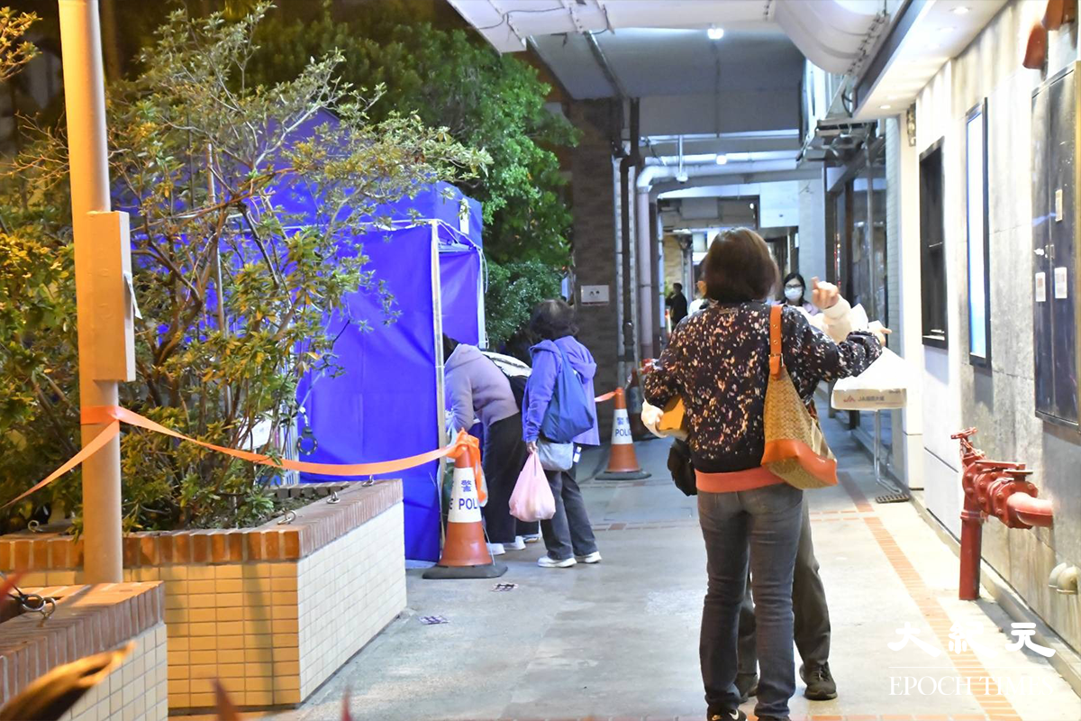 工作人員於荔灣道及蘭秀道交界，設置一個臨時登記站，為剛返回蘭秀道第5號及第7號的居民登記。（麥碧／大紀元）