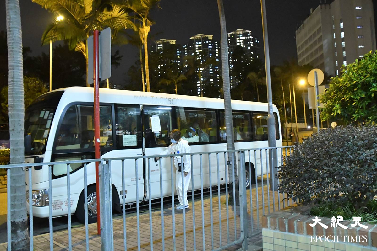 晚上9時，有一兩負責接送穿上全套白色保護裝備工作人員的小巴停泊在荔灣道等候。（麥碧／大紀元）