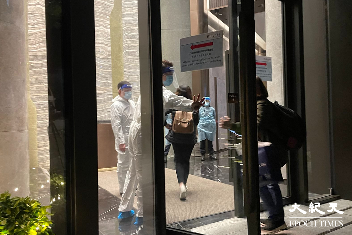 晚上7時25分，油塘四山街8號曦臺出入口，已經有穿著全套白色保護裝備的工作人員駐守。（卓相如／大紀元）