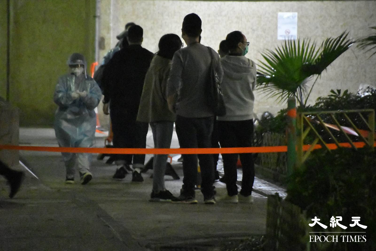 晚上8時15分，太和邨居和樓居民排隊等候登記返回家中。（麥碧／大紀元）