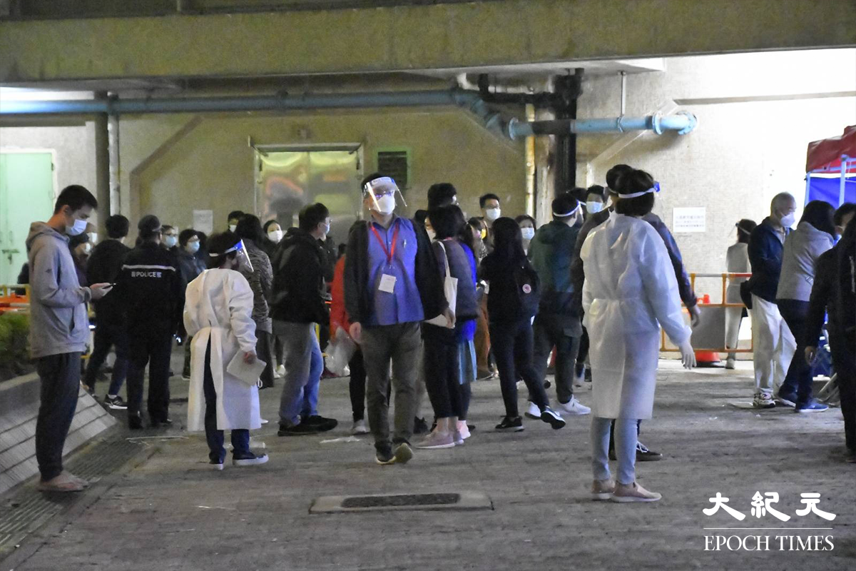 在場工作人員帶領太和邨居和樓居民，到臨時登記處登記接受強制檢測。（麥碧／大紀元）