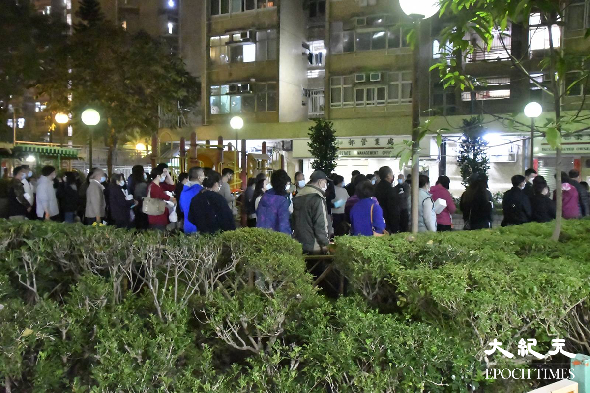 晚上9時，已完成檢測的居民，於居和樓對開一個休憩公園排隊等候返回家中。（麥碧／大紀元）
